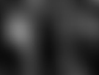 Bride and groom sharing their first dance during an elegant wedding reception while guests watch closely.