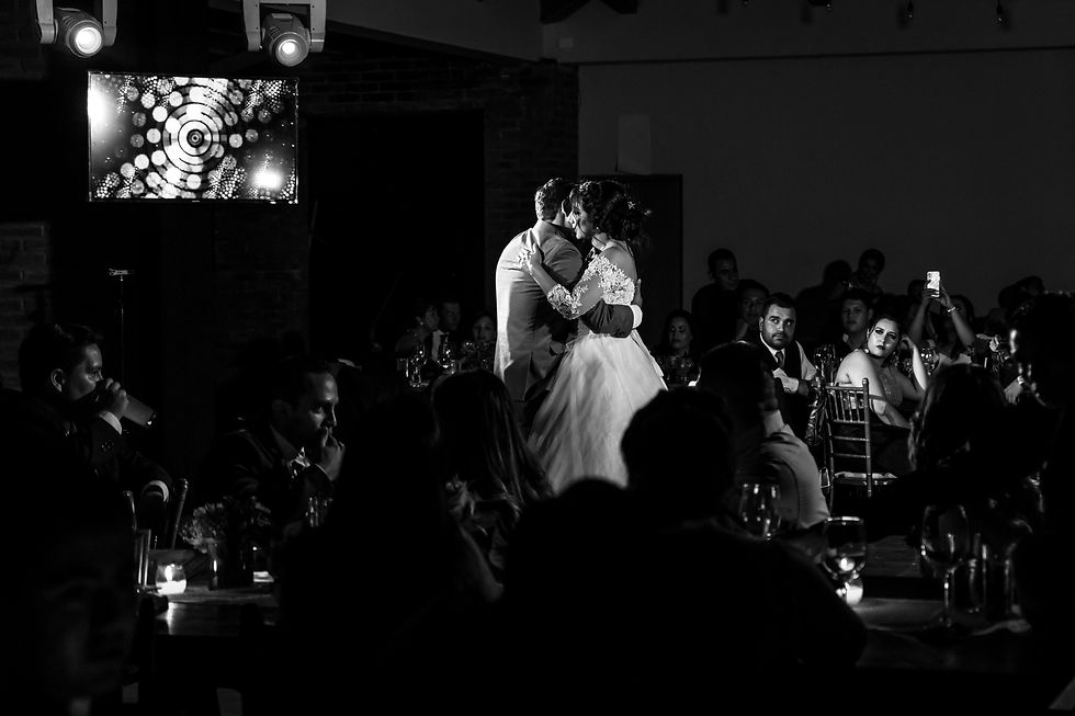 Couple sharing an intimate first dance during a wedding reception with focused spotlighting