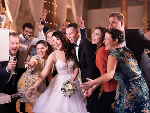 Wedding guests interacting at a luxury photo booth during a reception