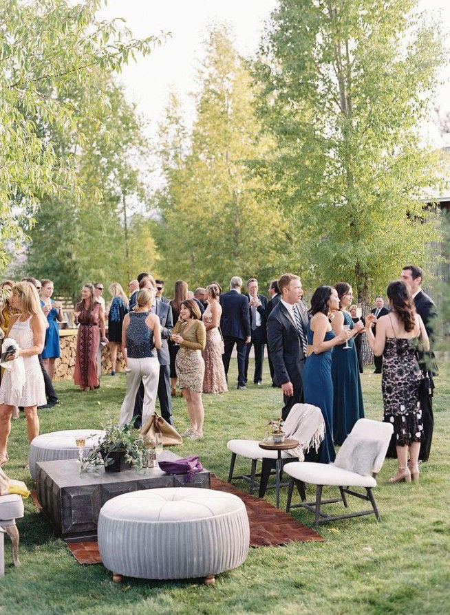 Guests enjoying an elegant outdoor wedding cocktail hour with comfortable lounge seating