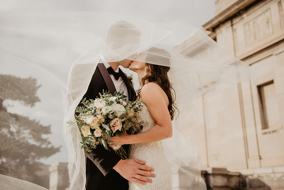 Emotional final wedding moment with the couple sharing a kiss under a flowing veil