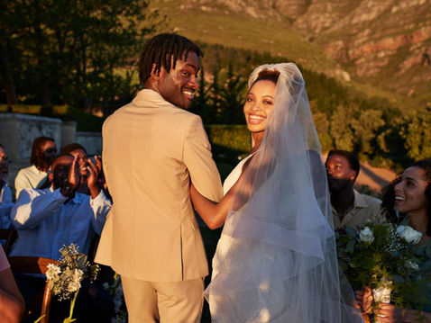 Newly married couple surrounded by celebrating wedding guests following the ceremony, creating anticipation for the luxury wedding reception.