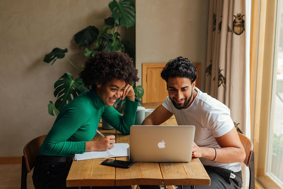 Couple planning wedding entertainment during a consultation meeting while reviewing reception music and timeline