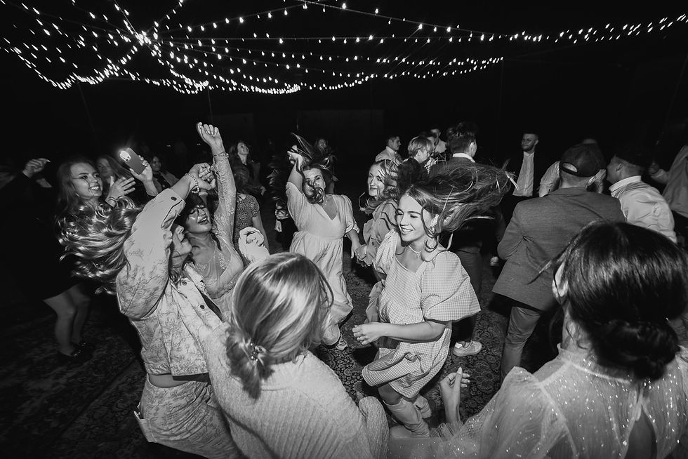 High energy wedding dance floor with guests celebrating under party lights