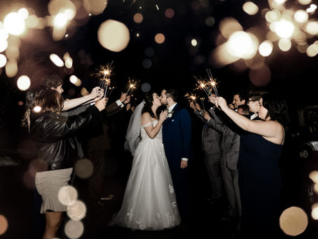 Couple sharing a kiss in sparkler exit wedding tunnel, highlighting wedding exit ideas with safe sparkler send off and magical sparkling wedding farewell.