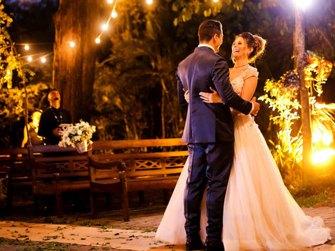 Bride and groom sharing a romantic first dance under string lights at a luxury outdoor wedding reception