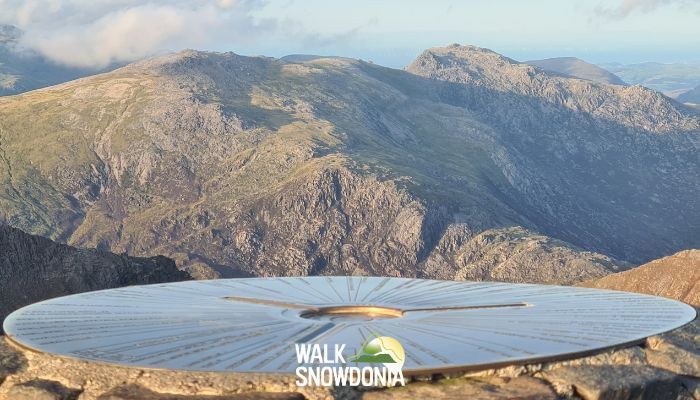 Glyder Fawr & Glyder Fach from Yr Wyddfa (Snowdon) with Snowdon summit disc and trig point in foreground, Glyder Fawr in midground and Glyder Fach in background on a clear day