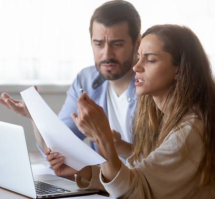 Un jeune couple nerveux qui examine l'avis de remboursement du prêt hypothécaire sur papier, se sent stressé par la résiliation. Les conjoints malheureux ayant des problèmes financiers, calculant les dépenses mensuelles.