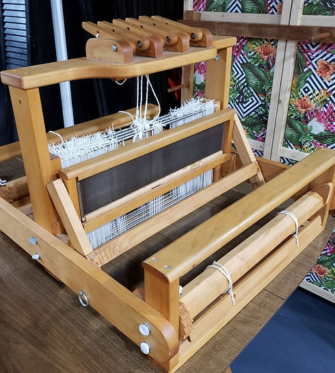 A Mountain Loom Co. 4-shaft 6-treadle table loom sitting on a table.