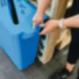60 litre blue confidential multisort paper bin, with a lady unlocking the bin