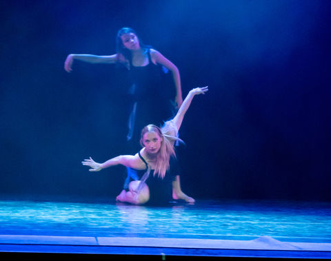 Deux danseuses en bleu sur fond bleu réalisent une figure osée