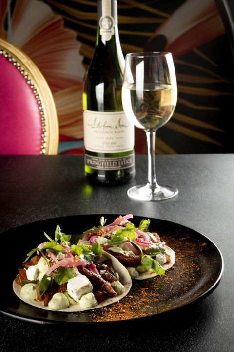 Salad dish and white wine at a restaurant in Sandton