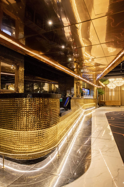 Gold reception desk and chandeliers in the Hotel Sky Cape Town lobby 
