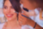 Smiling woman receiving professional makeup application, creating a glowing, radiant look for a special event