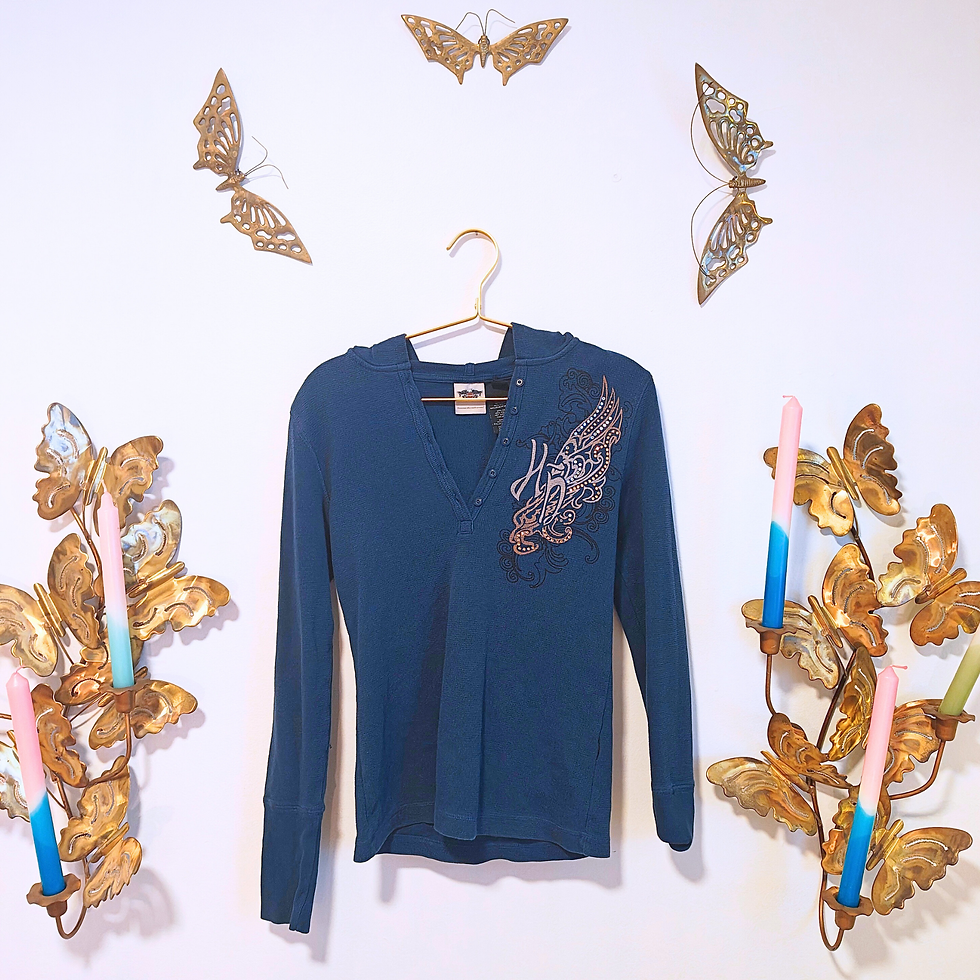 Thumbnail: Blue top with wings graphic; white wall decorated with butterflies and candles
