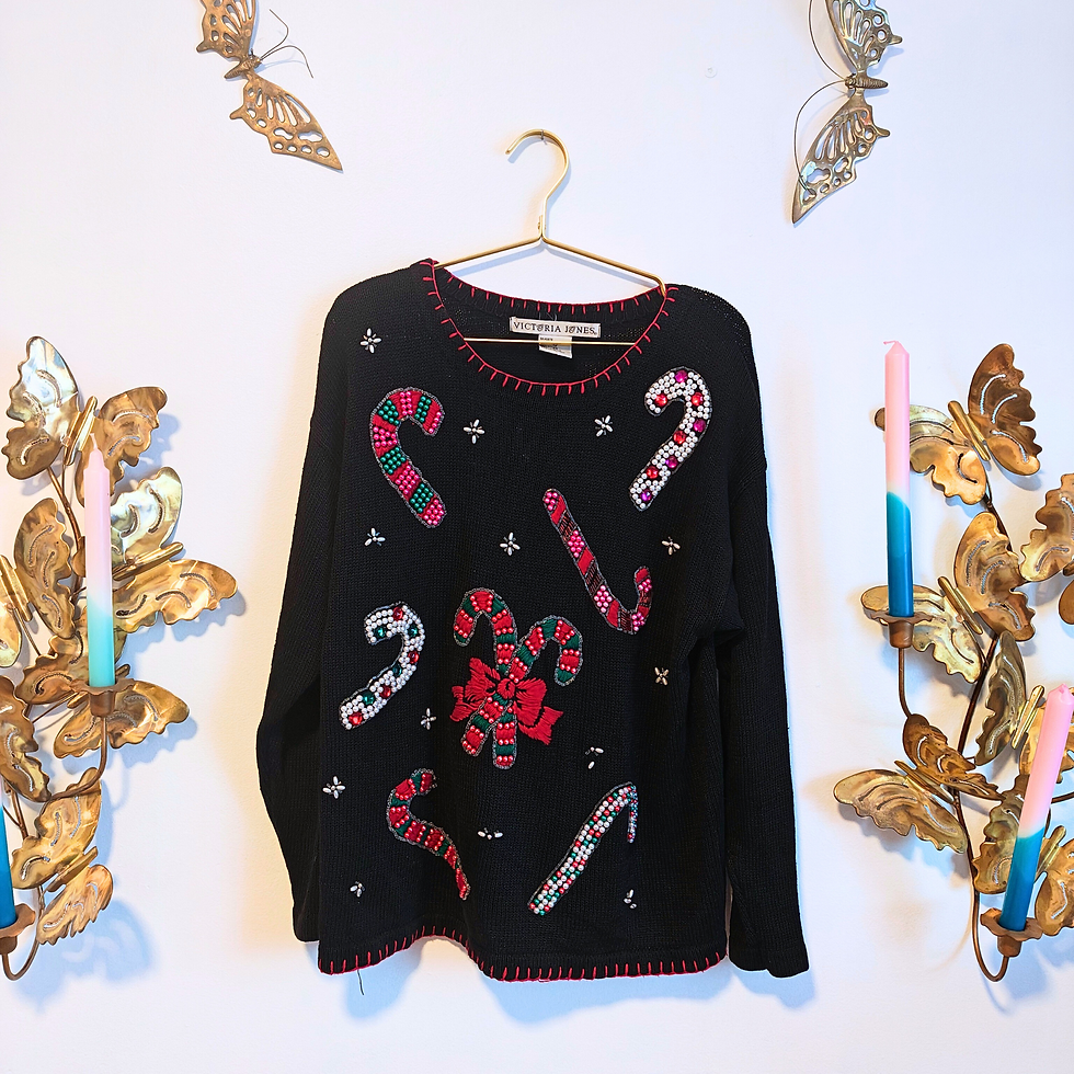 Thumbnail: Black Christmas sweater with candy canes hanging on a golden hanger, decoration.