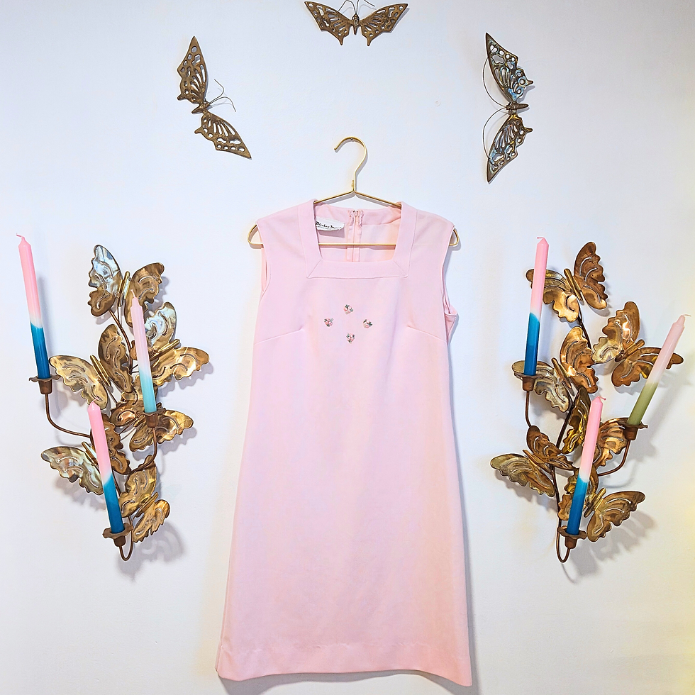 Thumbnail: Pink dress hanging on wall with butterflies and candles for decoration