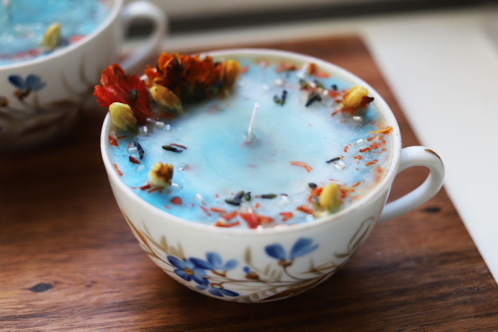 Thumbnail: Floral tea cup candle with blue wax and dried flowers on wooden board.
