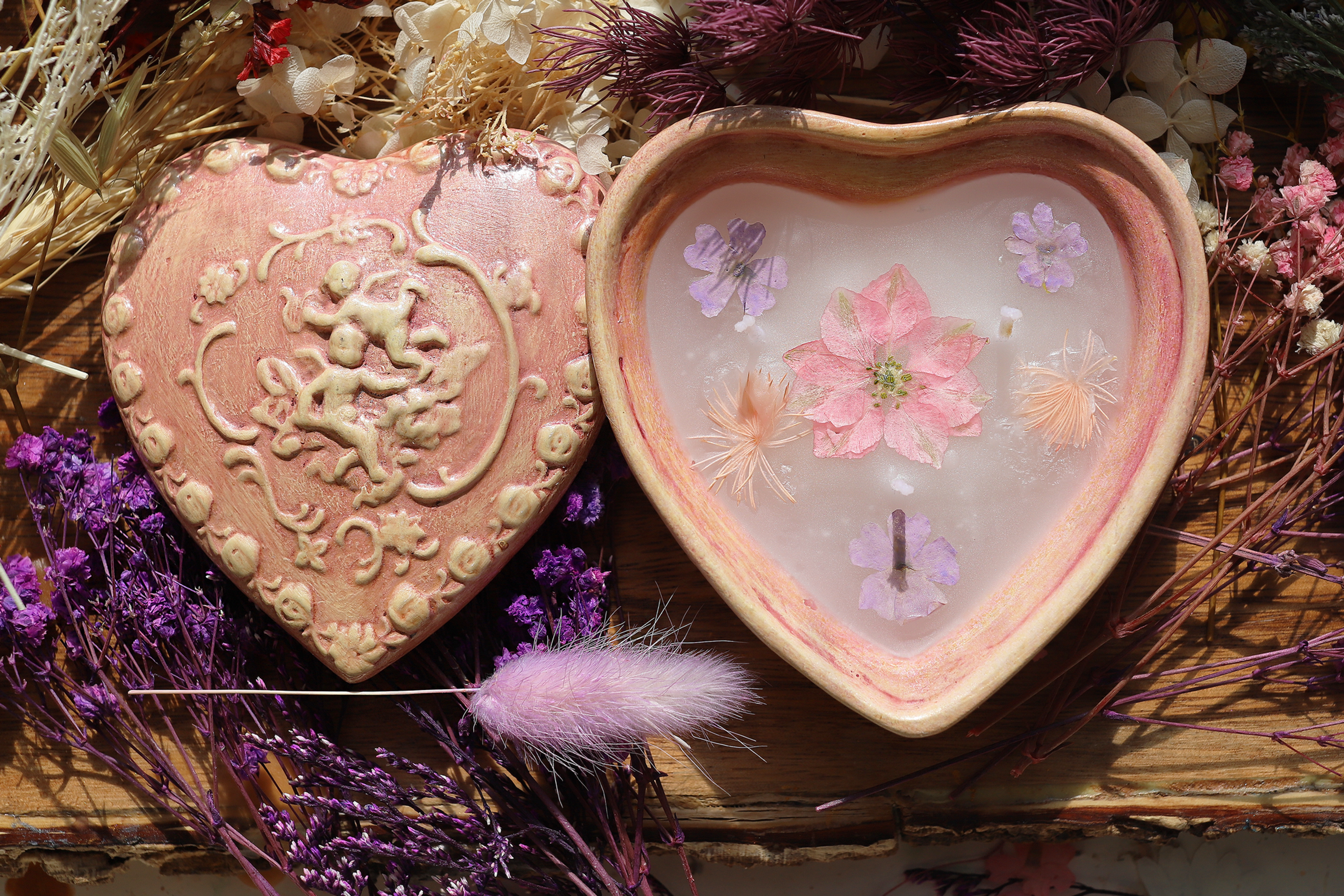 Pink heart-shaped bowl with flowers and decorative items. Romantic and aesthetic.