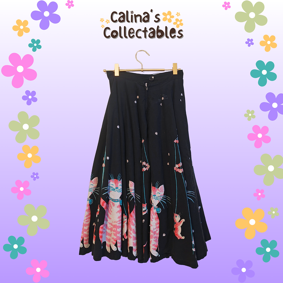 Thumbnail: Black skirt with cat design, Calina's Collectables, hanging in front of flowers.