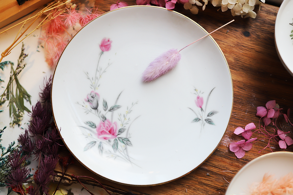 Thumbnail: White plate with floral design and pink flower detail on wooden table