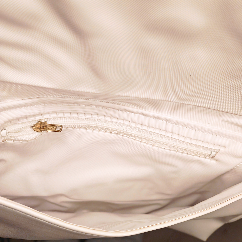 Thumbnail: Inside view of a cream colored purse with small zippered pocket.