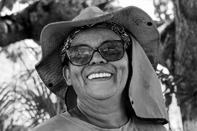 Smiling woman wearing hat and sunglasses outdoors, happy portrait, Série Recôncavo Baiano