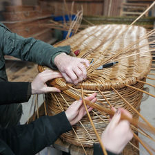 Hands weaving willow coffin