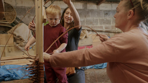 Family weaving together with guidance from Sophia at the Devon workshop