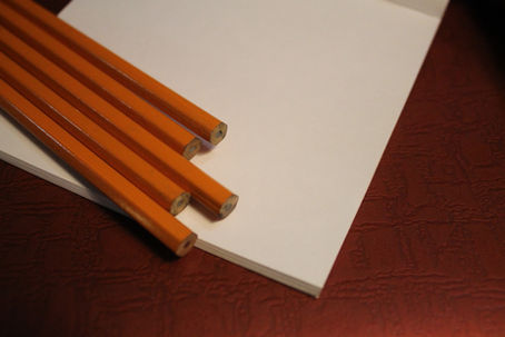 Pencils on white paper red background