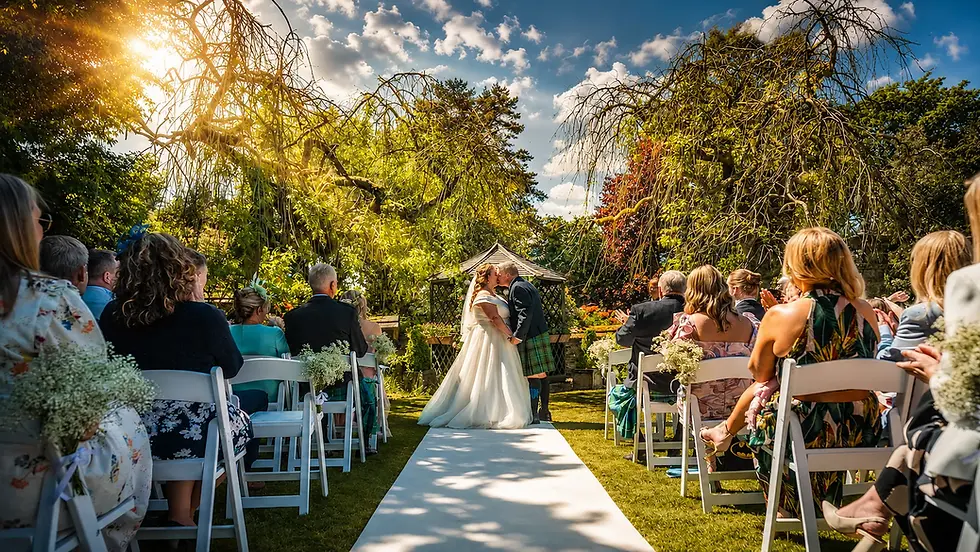 Outdoor wedding ceremony at Holdsworth House, Halifax, with bride and groom sharing their first kiss in the gardens, wedding photography by Paul Walker Photography