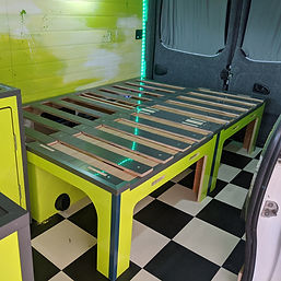 Lift-up campervan bed revealing storage space underneath, crafted by V4N5 Campers