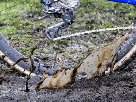 A wheel goes through a small puddle during the racing throwing up some muddy water