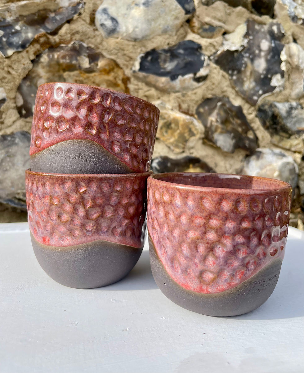 handmade ceramic mug with texture, black clay and a deep berry red glaze