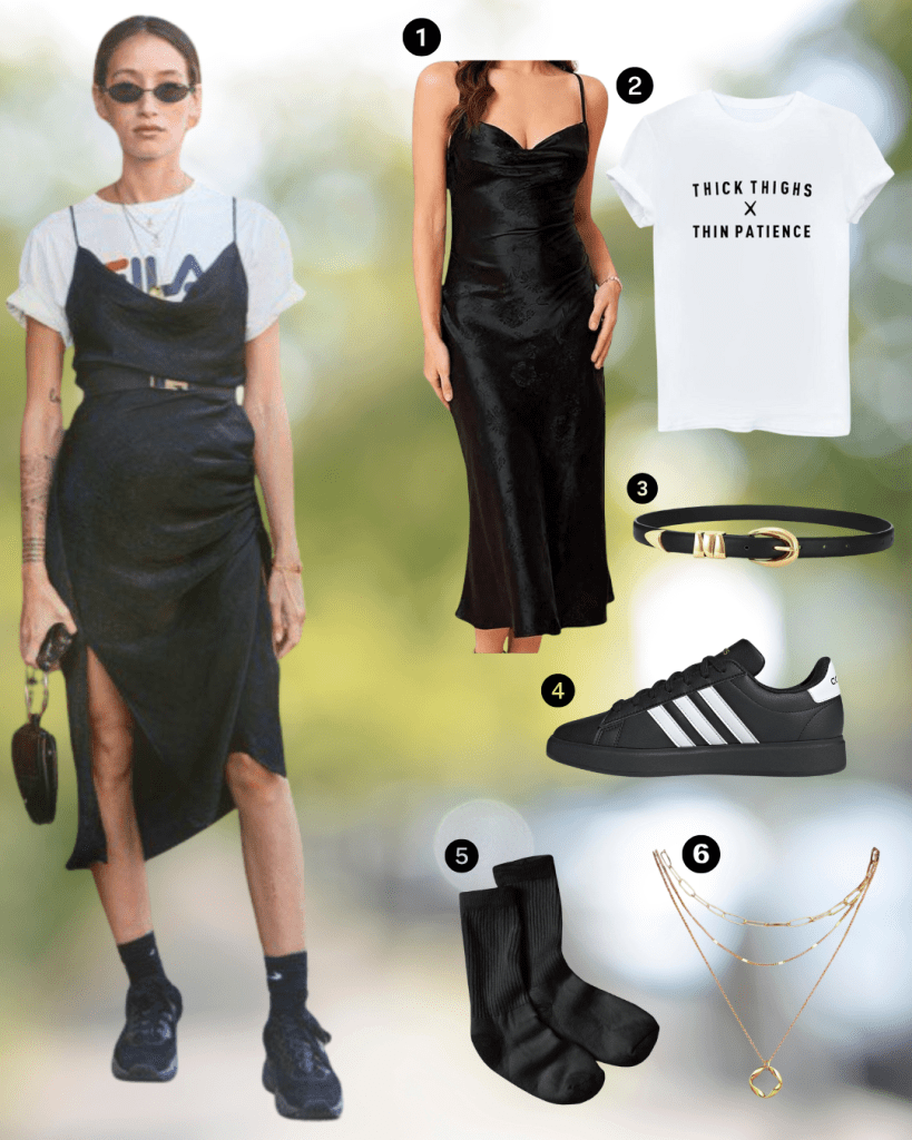 A woman wearing a black slip dress over a white t-shirt, styled with a belt, sneakers, and black socks, standing outdoors with a small bag.