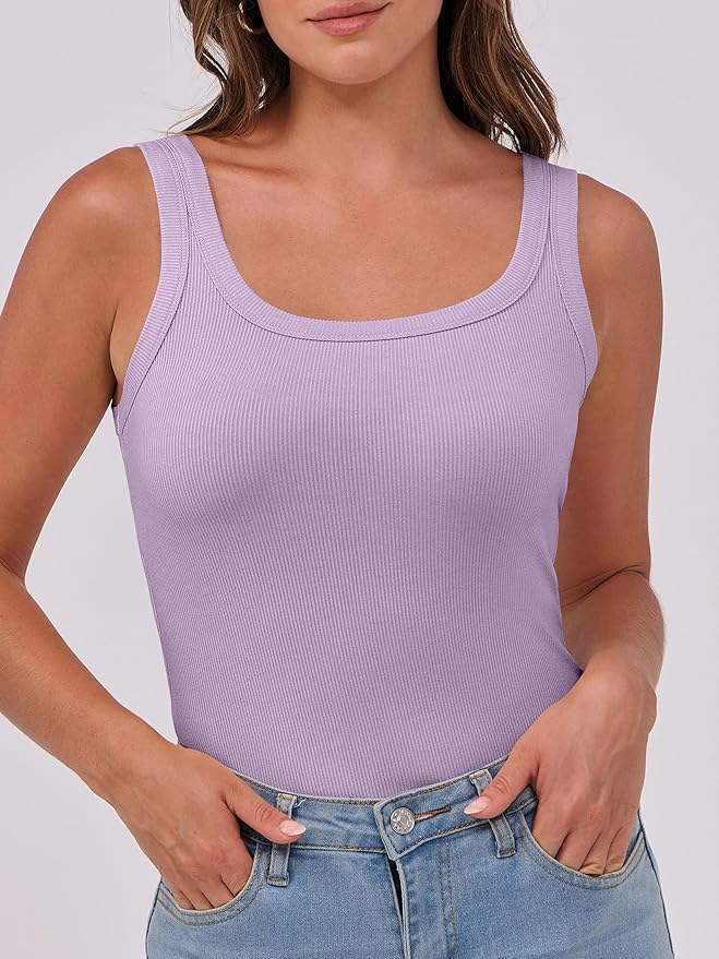 A woman wearing a light purple ribbed tank top, paired with light blue high-waisted denim shorts. She stands with a relaxed posture, hands on her hips, against a plain background.