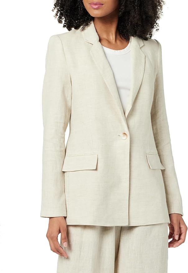 A woman wearing a light beige blazer over a white top, showcasing a polished and sophisticated look.