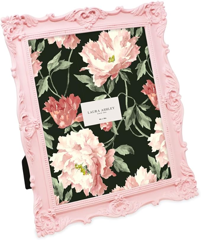 A pink ornate picture frame with floral design and a label stating 'Laura Ashley' inside.