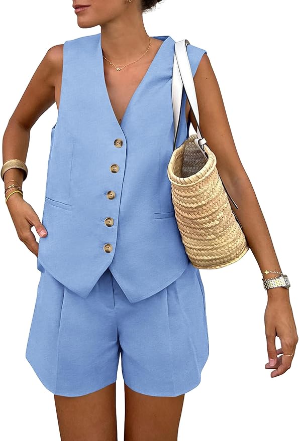 A woman wearing a light blue matching set, featuring a sleeveless button-down vest and tailored shorts, holding a woven straw bag.