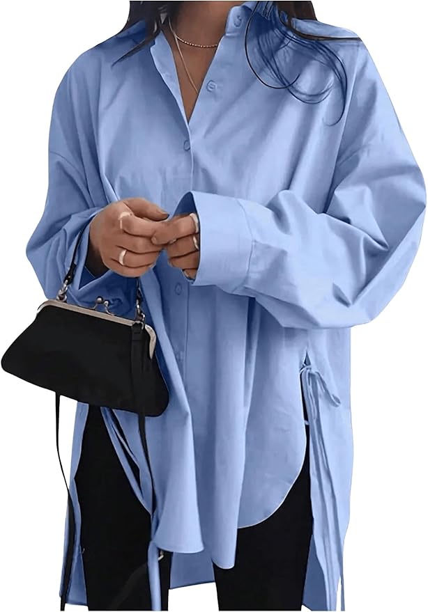 A person wearing an oversized light blue button-down shirt, holding a small black handbag, with their hair partially visible.