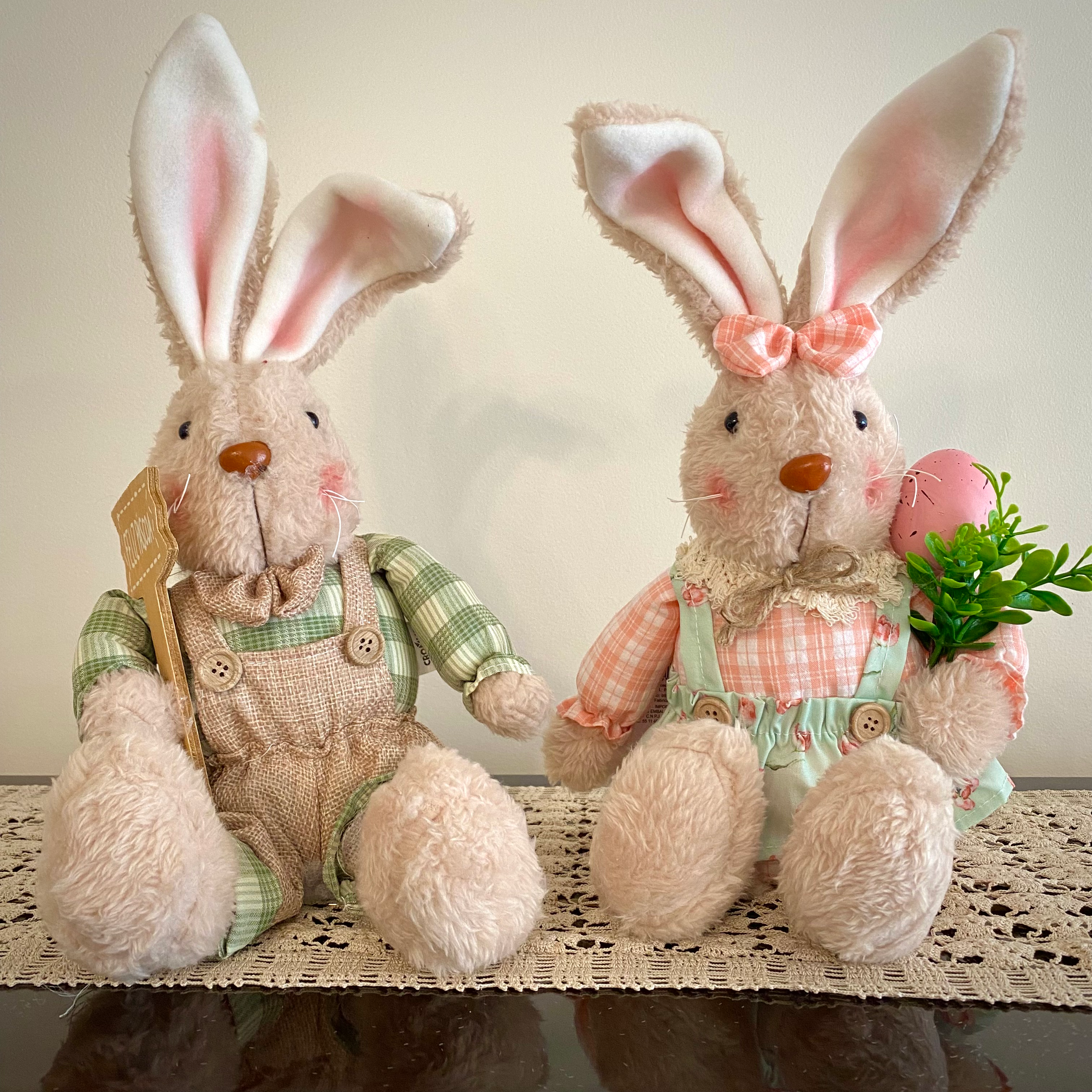 Casal de coelhos decorativos sentados.