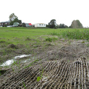 geotextile fabric across green landscape with houses on the horizon