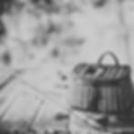 Black and white picture of a fly fishing rod sitting next to a wicker creel