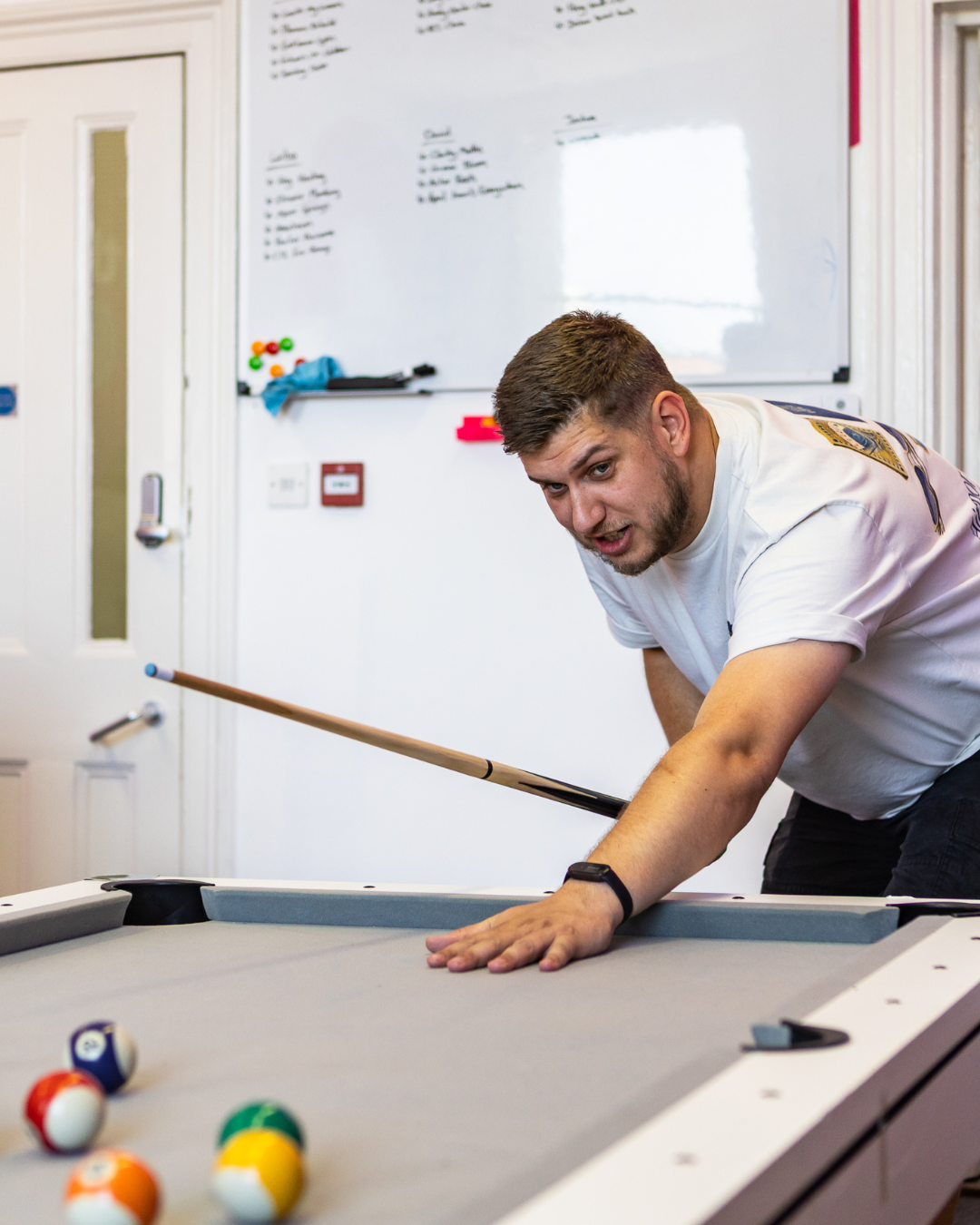 Karl Cowell playing pool in The Wix Guys office
