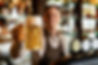 closeup-barista-holding-glass-craft-beer-bar