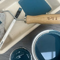 Blue paint in pot with roller, brush and tray ready to use