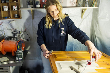 Louise painting a kitchen door in the studio