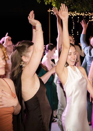 Wedding guests dancing on a packed dancefloor in Spain with DJ creating a lively party atmosphere