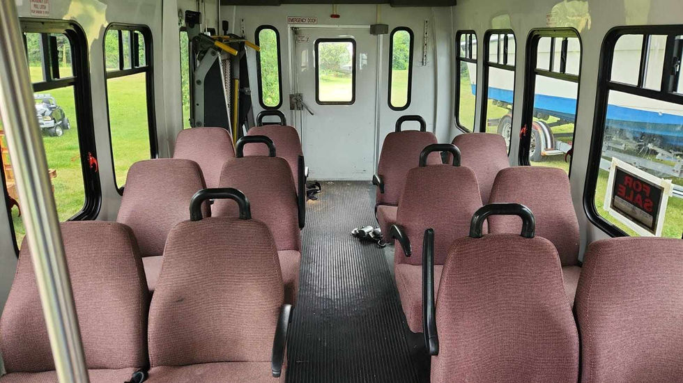 Mitzvah Tank pre-conversion interior, showing the original shuttle bus seating layout before customization.