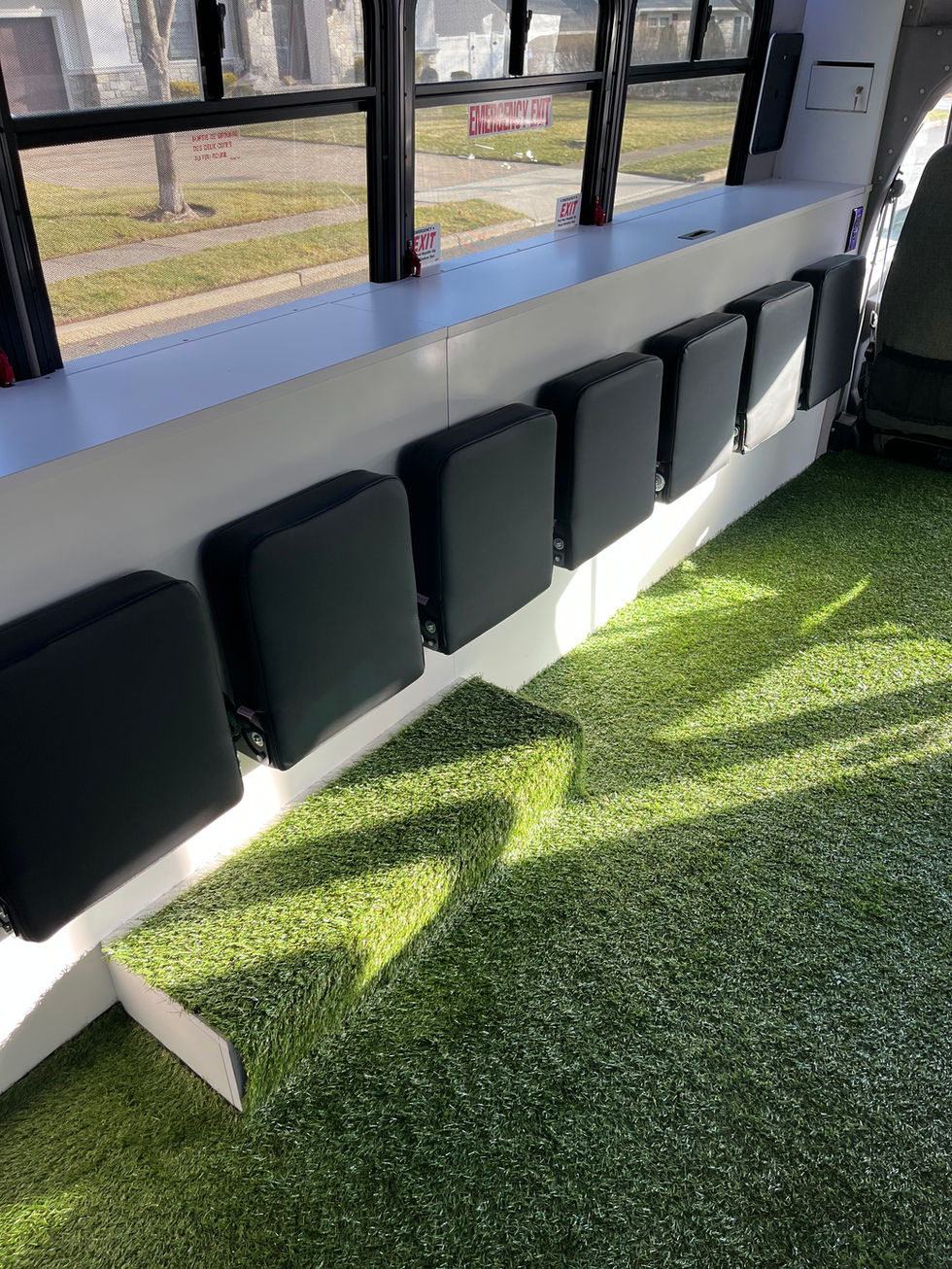 Mitzvah Tank 4 full-length interior with pop-down seating, hidden storage, turf flooring, and immersive stadium decor.
